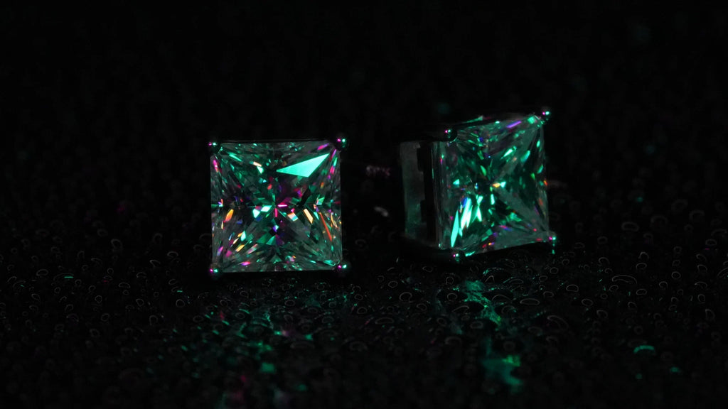 Moissanite Ohrstecker im Princess Cut. Funkelnd in grünem Licht.