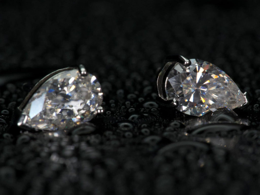 Echte Fotos von Moissanite Ohrsteckern im Tropfenschliff in Seitenansicht – sichtbare Fassung und eingesetzter Pear Cut Stein, dezentes Funkeln im Licht, 925 Sterling Silber mit Weißgold Veredelung