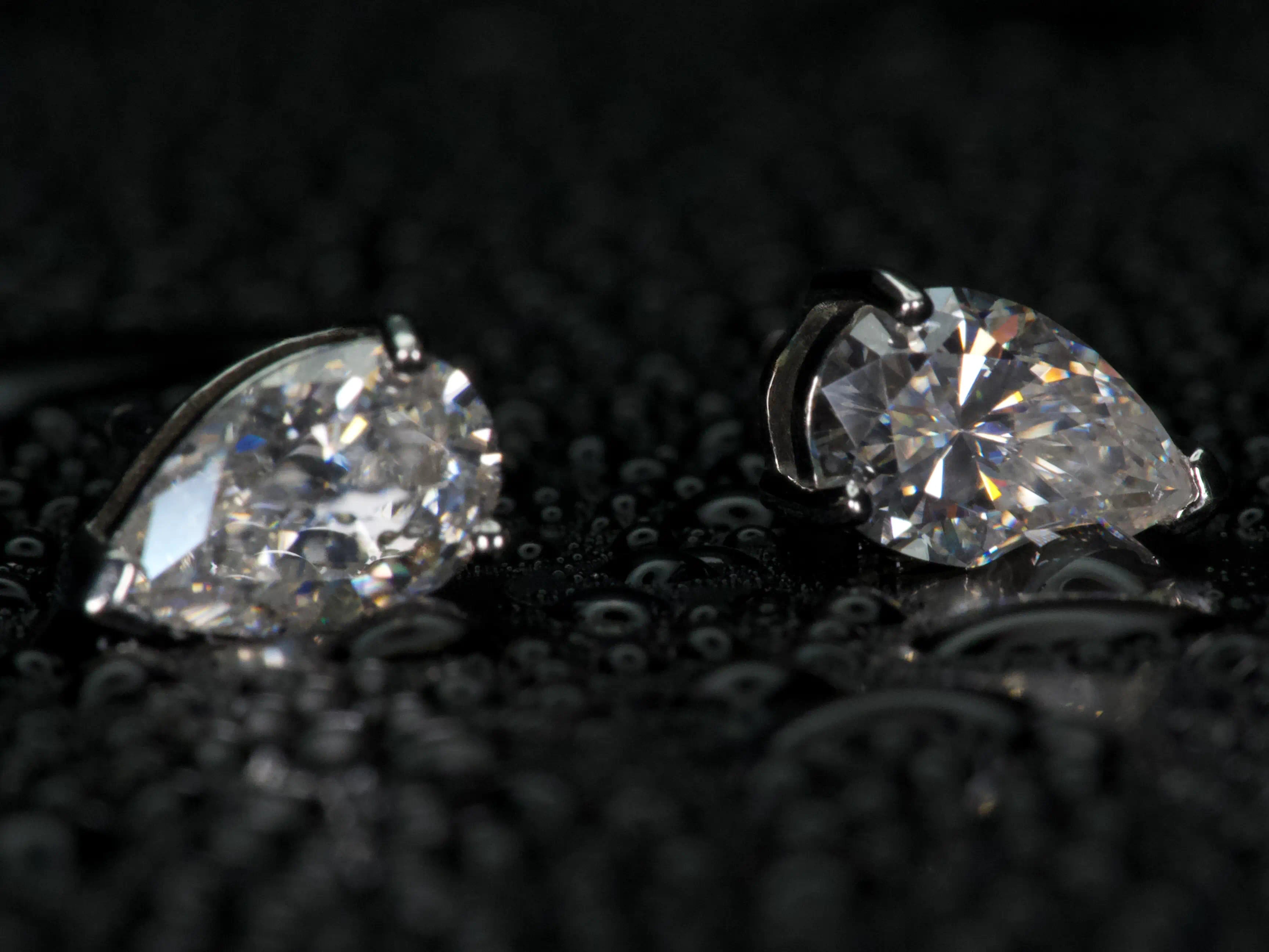 Echte Fotos von Moissanite Ohrsteckern im Tropfenschliff in Seitenansicht – sichtbare Fassung und eingesetzter Pear Cut Stein, dezentes Funkeln im Licht, 925 Sterling Silber mit Weißgold Veredelung
