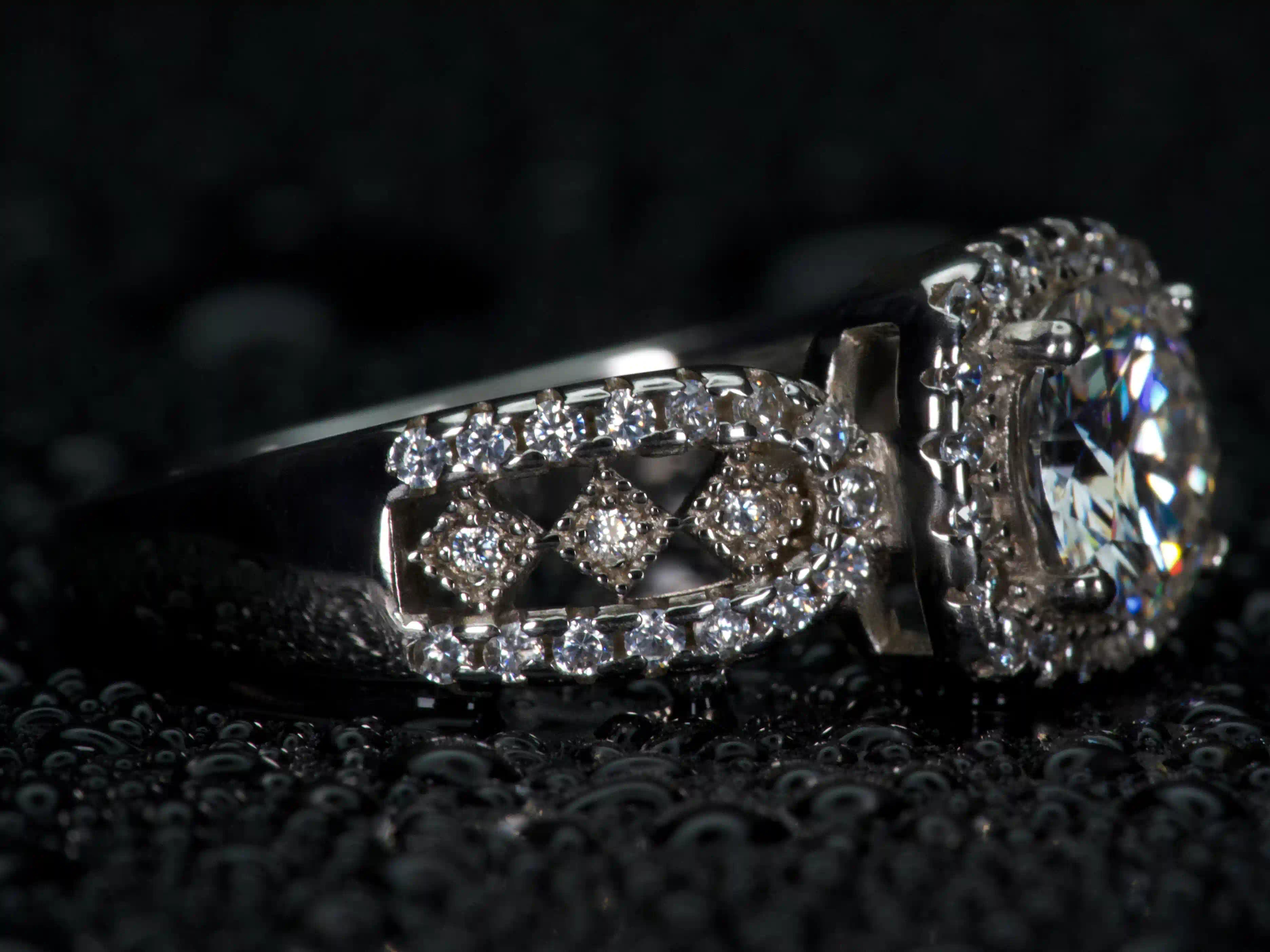 Moissanite Halo Ring von der Seite fotografiert, sichtbare Fassung und Aufbau mit starkem Lichtspiel, echtes Funkeln im realen Licht