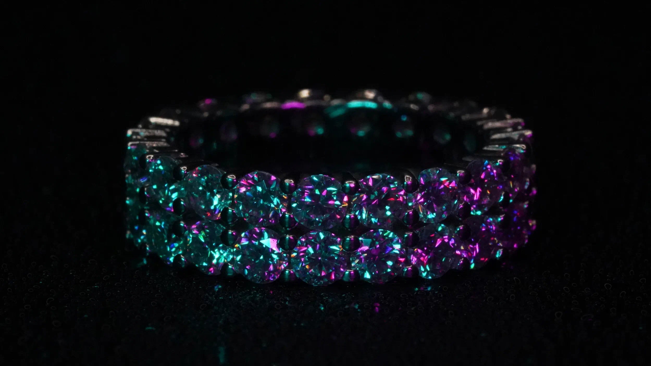 Moissanite ring mit Moissaniten rundum besetzt funkelnd lila in dunklem Licht