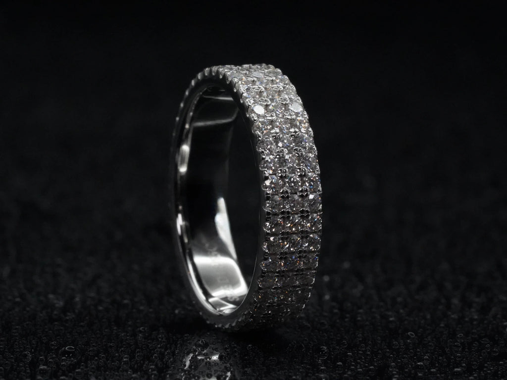 Moissanite Eternity-Ring mit drei Steinreihen stehend fotografiert – zeigt komplette Brillantfläche, dreifacher Aufbau in 925 Sterling Silber mit starker Lichtreflexion