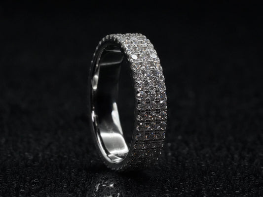 Moissanite Eternity-Ring mit drei Steinreihen stehend fotografiert – zeigt komplette Brillantfläche, dreifacher Aufbau in 925 Sterling Silber mit starker Lichtreflexion