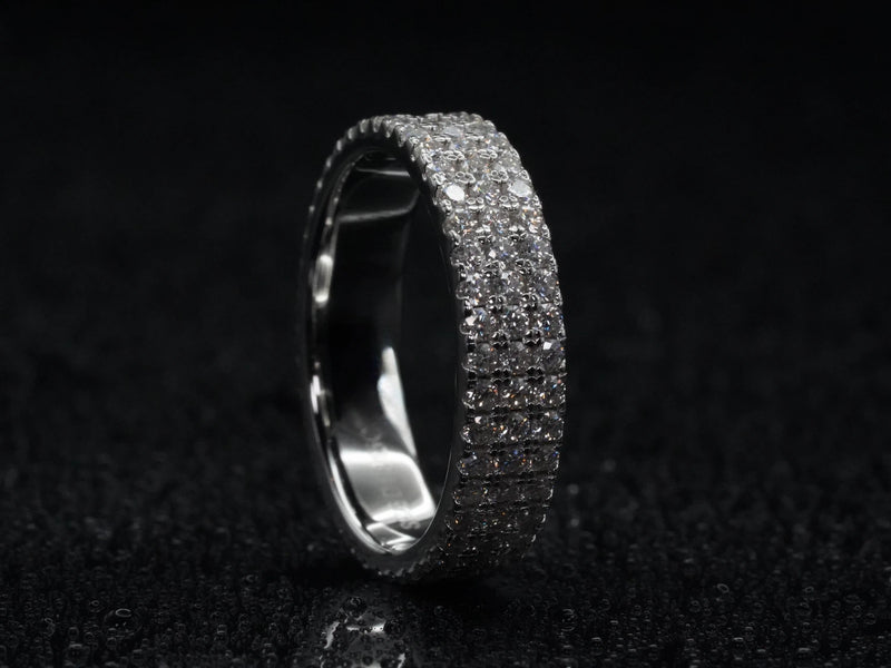 Moissanite Eternity-Ring mit drei Steinreihen stehend fotografiert – zeigt komplette Brillantfläche, dreifacher Aufbau in 925 Sterling Silber mit starker Lichtreflexion