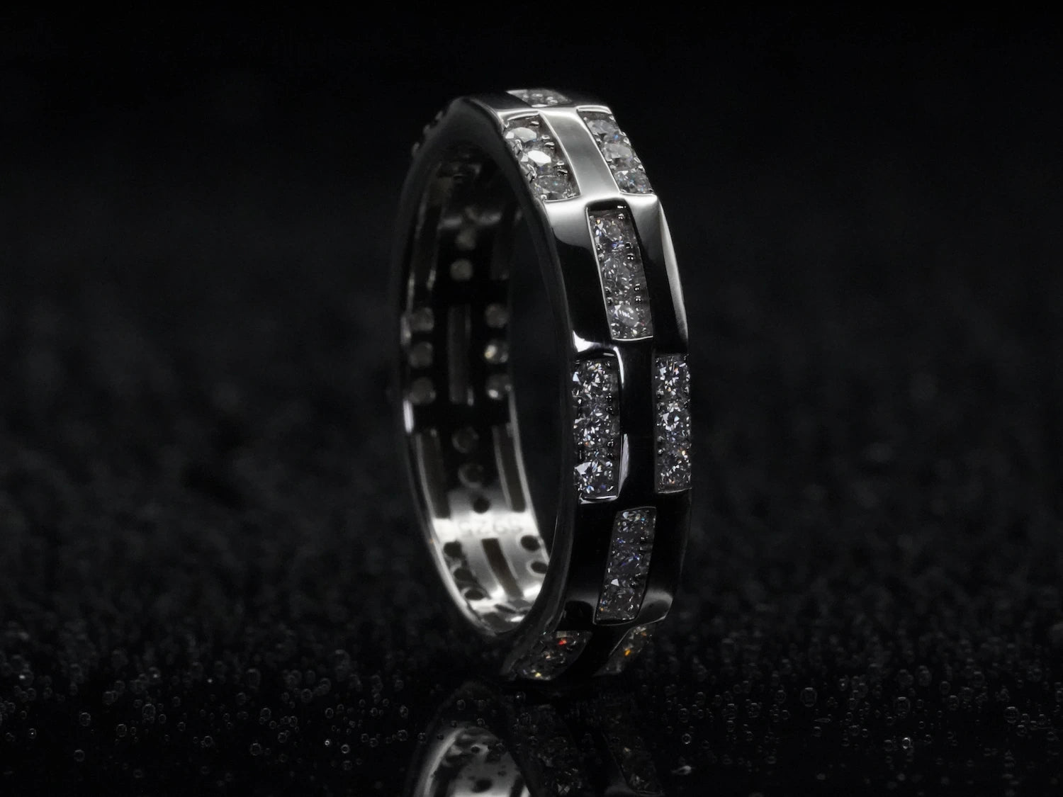 Moissanite-Ring mit Musterstruktur stehend fotografiert – aufrecht präsentiert, zeigt Brillantschliff und dekorative Struktur auf 925 Sterling Silber in voller Klarheit