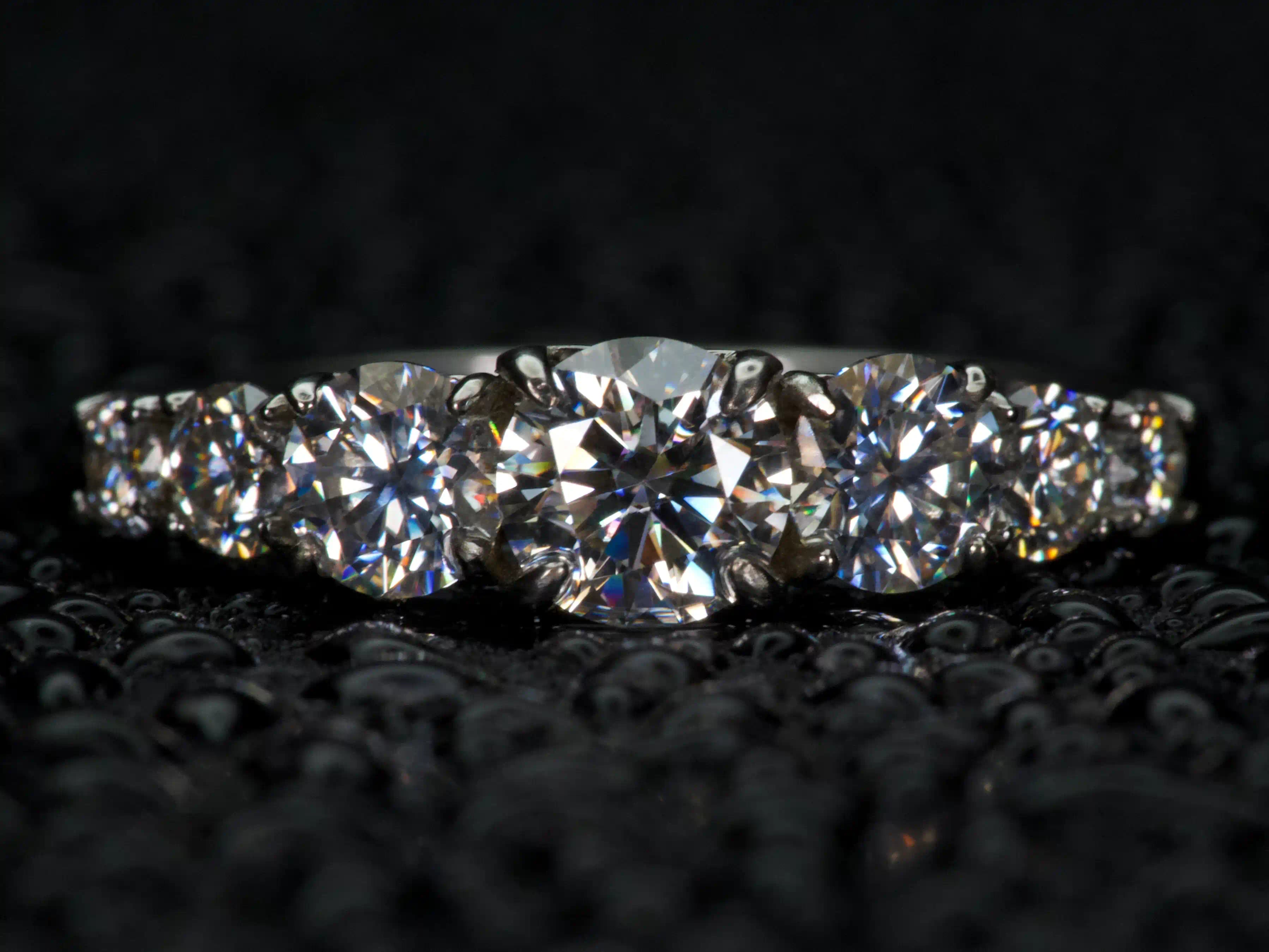 Moissanite Ring mit 5 Steinen im Größenverlauf frontal aufgenommen, extremes Funkeln wie Diamant bei echtem Licht, 925 Silber & 18K Weißgold, echte Fotos ohne KI