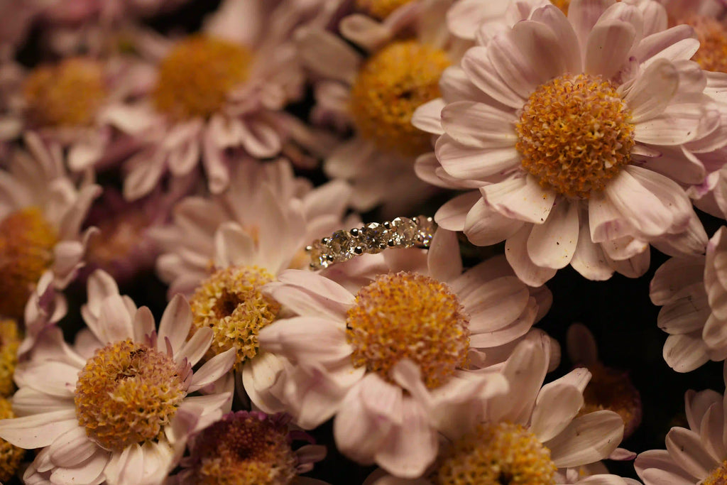 Moissanite Ring aus 925 Silber mit Weißgold Veredelung in Blumen fotografiert – echtes Funkeln im natürlichen Licht, echte Fotos ohne KI