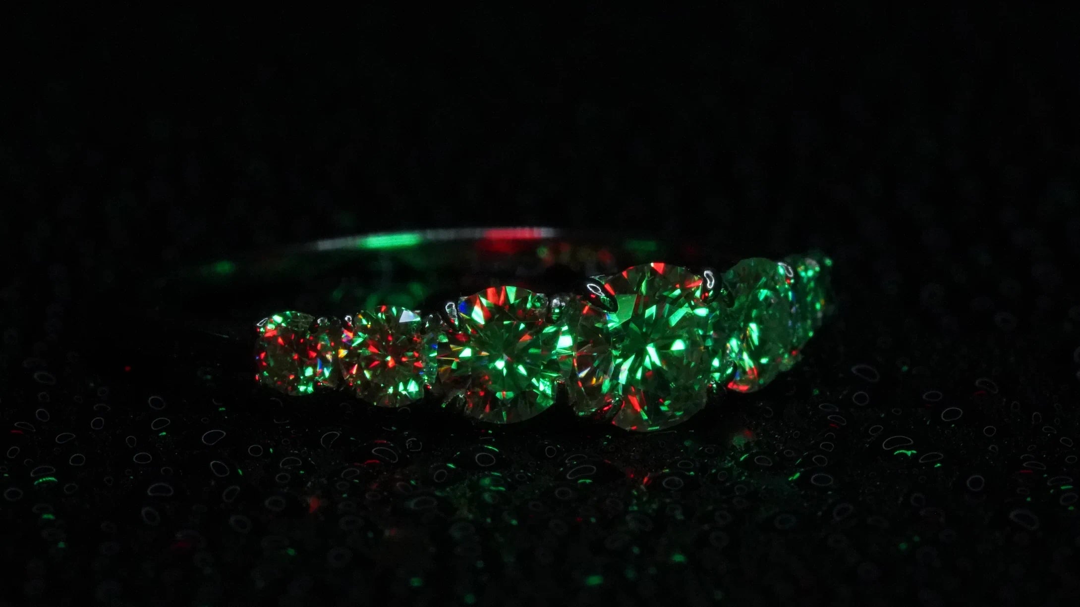 Moissanite Ring mit Größenverlauf der Steine in grünem Licht