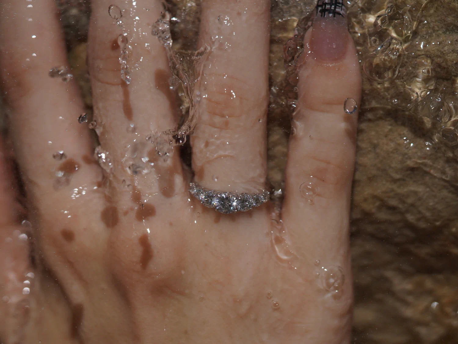 Moissanite Ring aus Sterling Silber mit abgestuften Steinen im Wasserlicht – moderner Moissanite Schmuck mit fließender Form, Weißgold-Finish und harmonischem Funkeln.