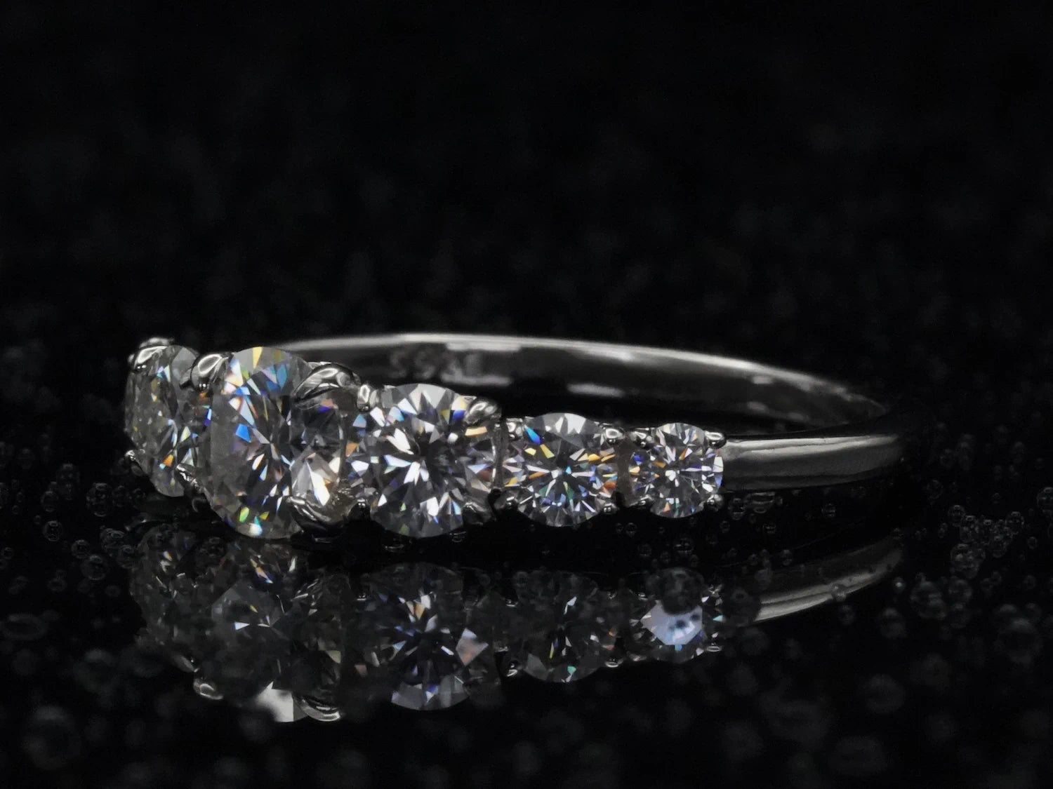 Seitliche Ansicht des Moissanite-Rings mit Größenverlauf – zeigt ansteigende Steinabfolge in hochwertiger Silberringschiene mit klarer Struktur und Glanz