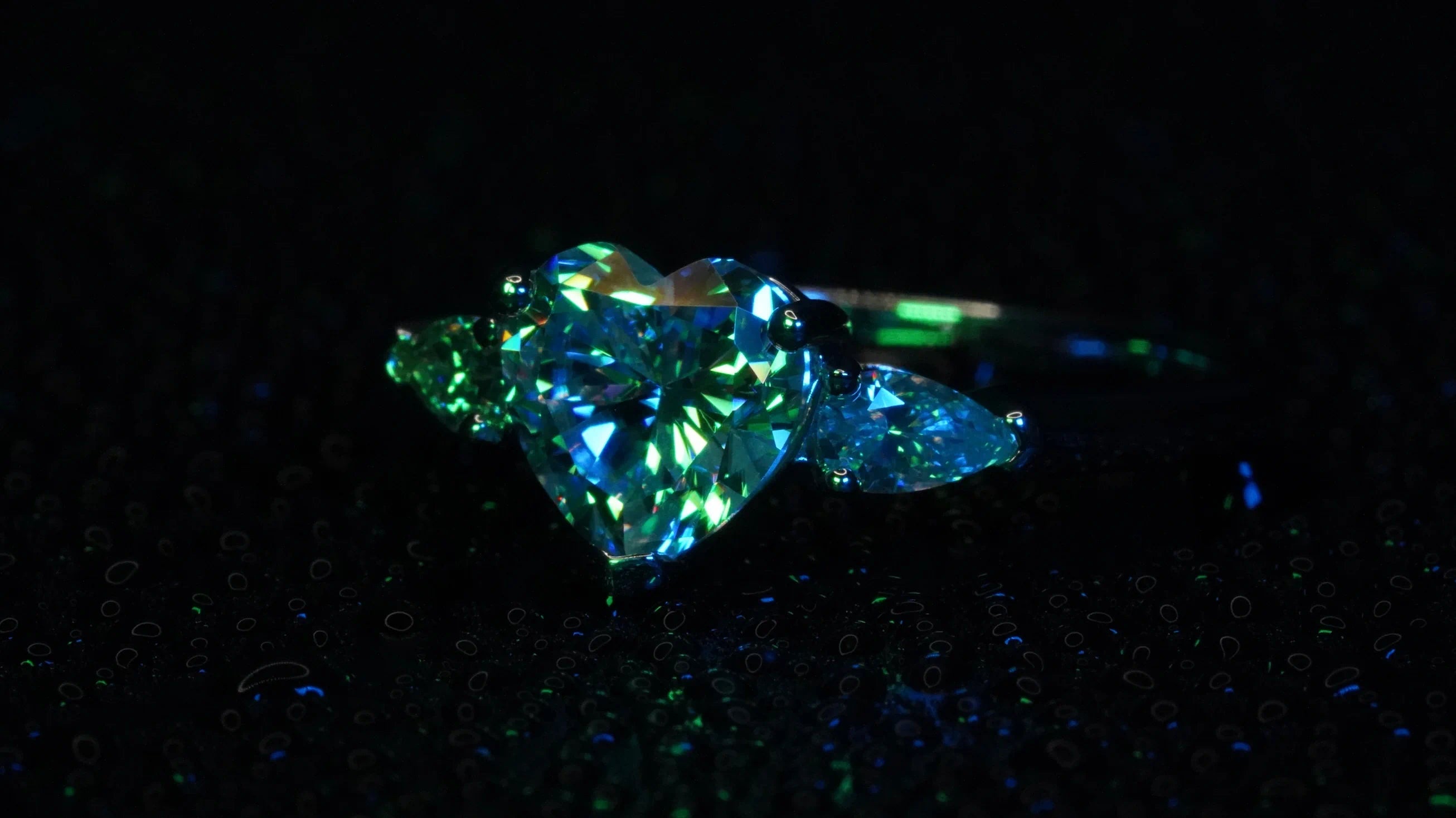 Moissanite Verlobungsring mit Herz-Schliff funkelt blaues und grünes Licht zurück