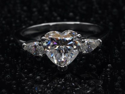Draufsicht auf den Moissanite-Ring mit Herz- und Tropfenstein – asymmetrisches Design mit klarer Fassung beider Steine auf silberner Ringschiene