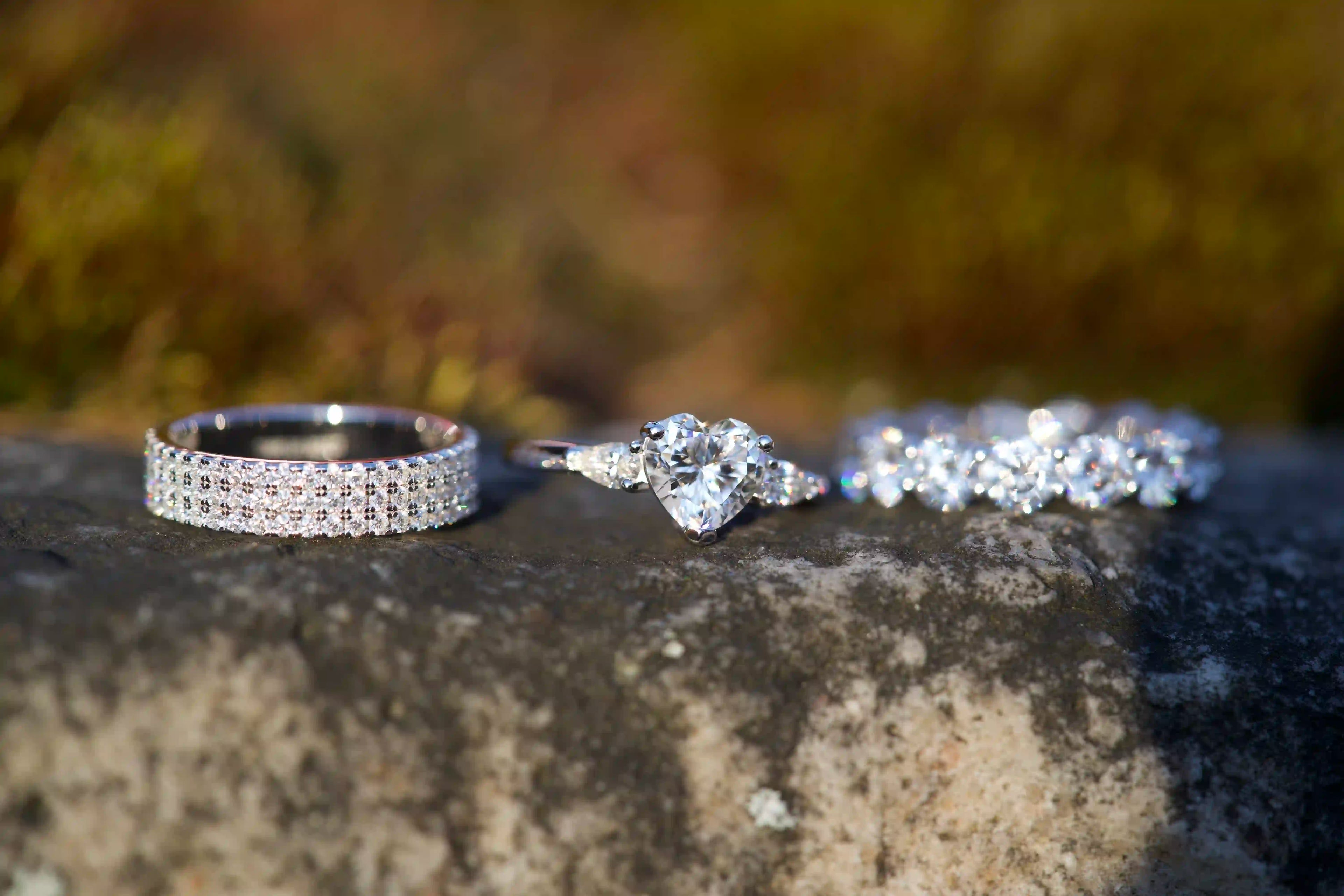 Moissanite Ringe aus 925 Sterling Silber mit Herz Ring und Eternity Ring auf Naturstein im Sonnenlicht