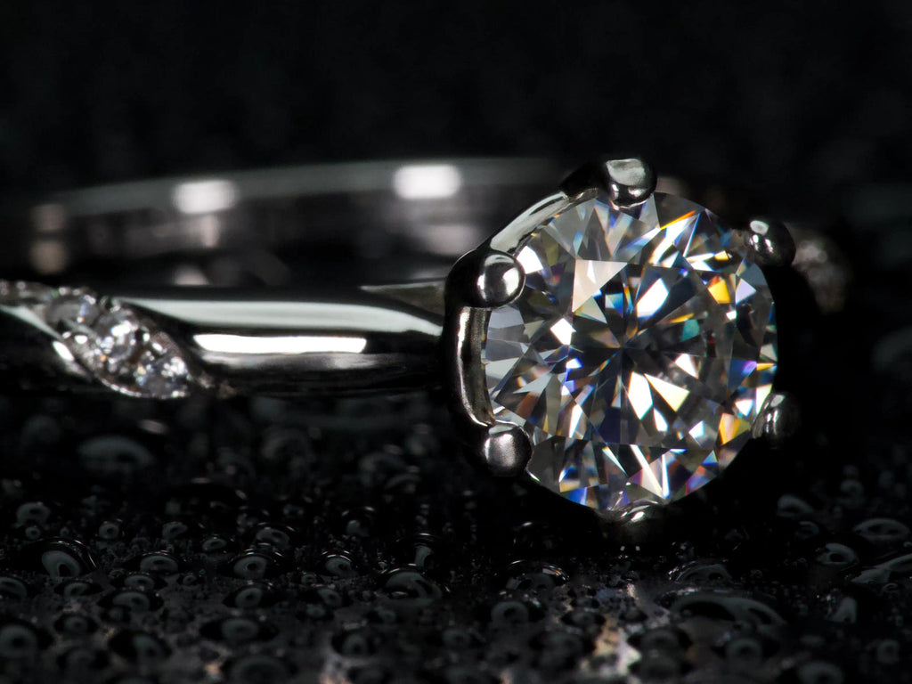 Moissanite Solitär Ring von der Seite fotografiert, sichtbare Fassung und Aufbau des Steins mit starkem Lichtspiel im echten Licht