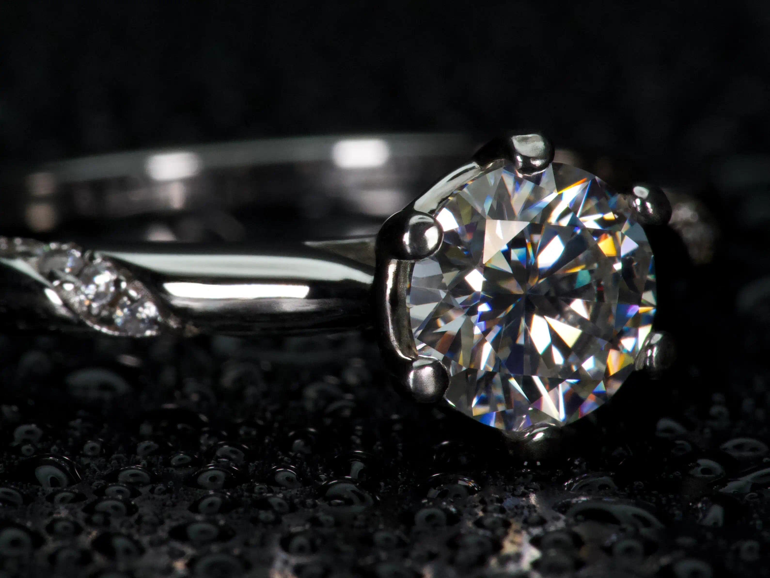 Moissanite Solitär Ring von der Seite fotografiert, sichtbare Fassung und Aufbau des Steins mit starkem Lichtspiel im echten Licht