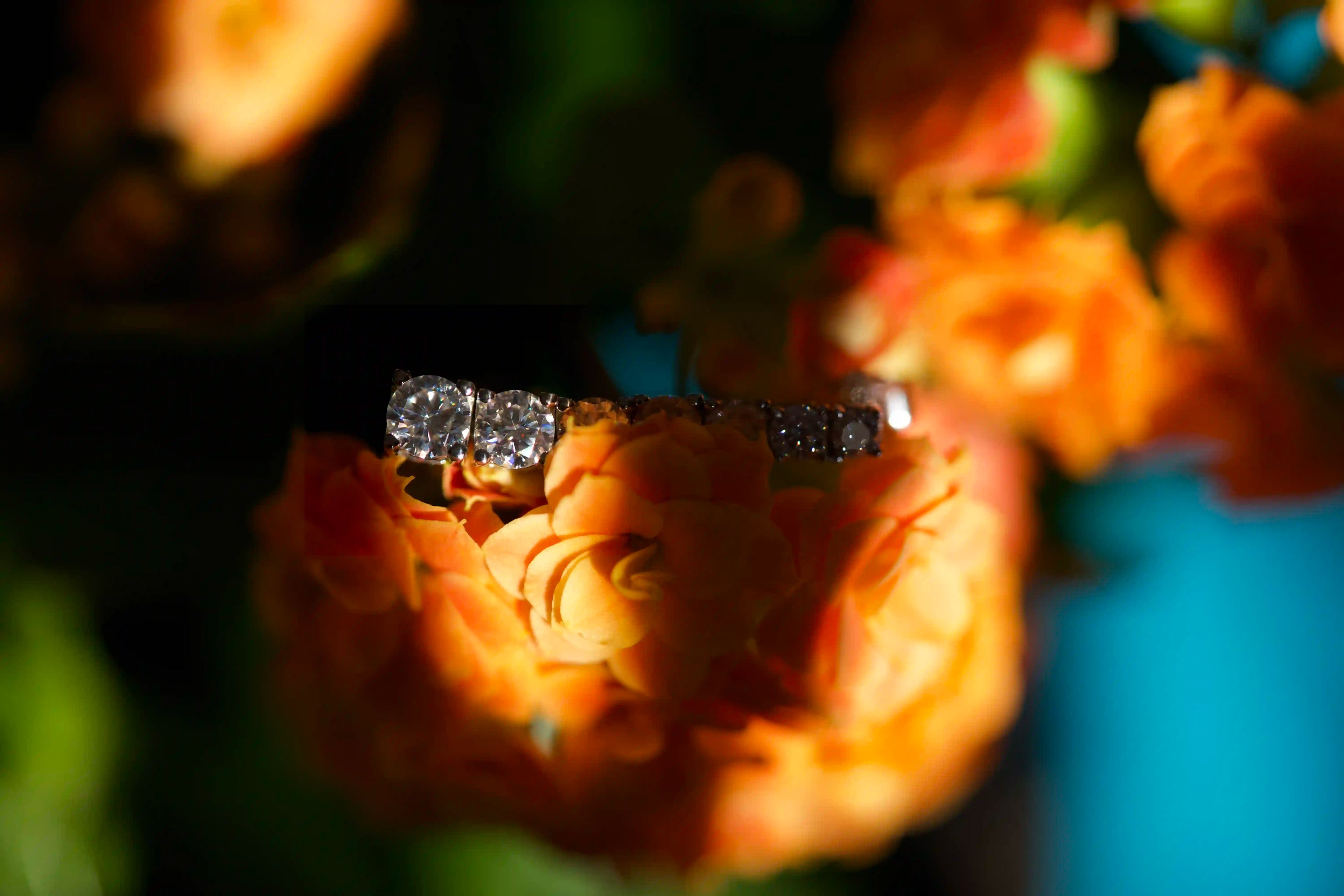 Edle Moissanite Ohrstecker mit verschiedenen Moissanite Steinen auf einer Orangen Blume