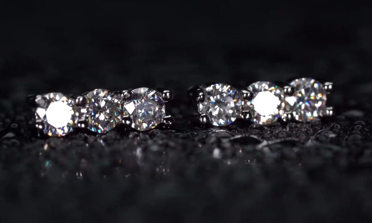 Video der Moissanite Ohrstecker mit 3 Steinen in gerader Reihe im echten Licht mit dauerhaft starkem Funkeln.