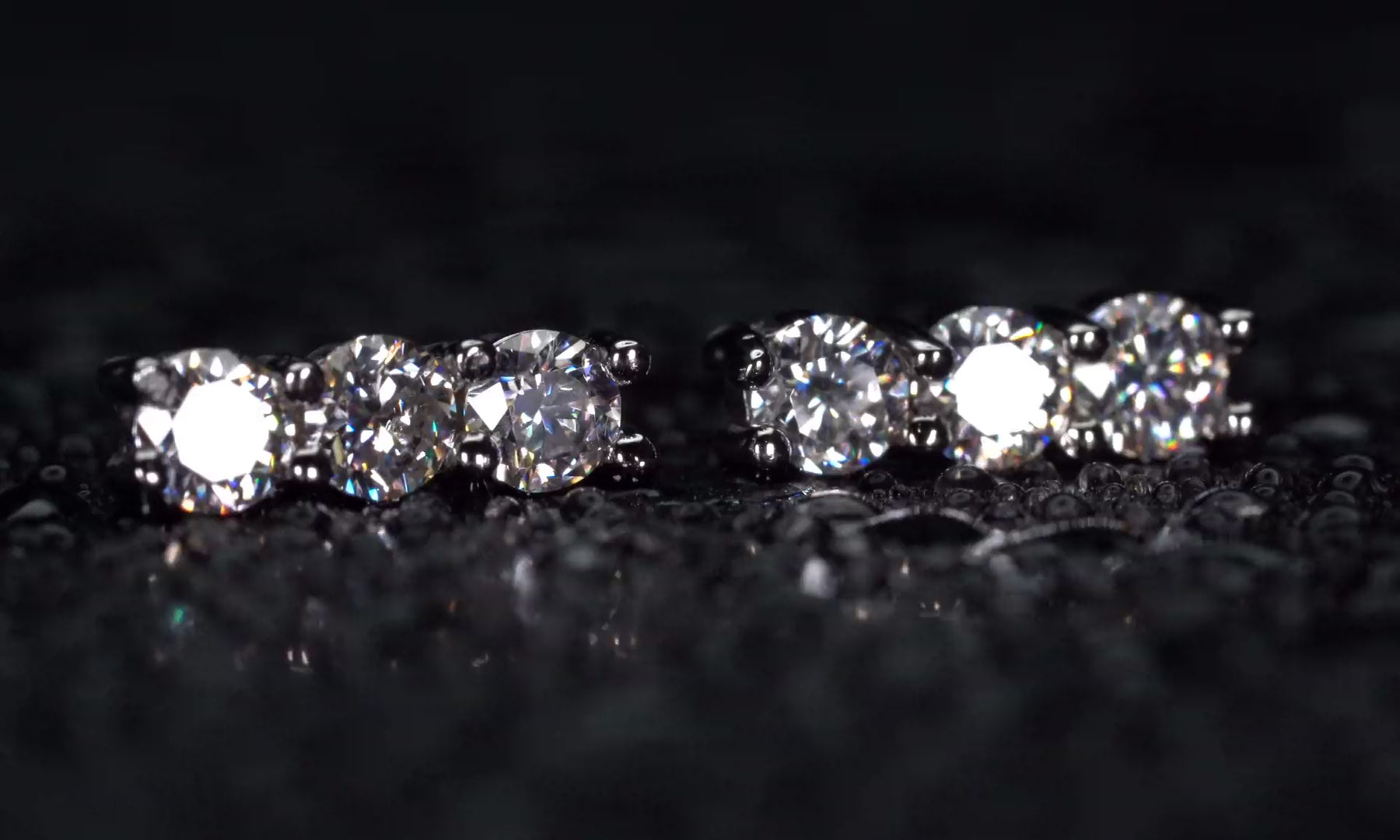 Video der Moissanite Ohrstecker mit 3 Steinen in gerader Reihe im echten Licht mit dauerhaft starkem Funkeln.