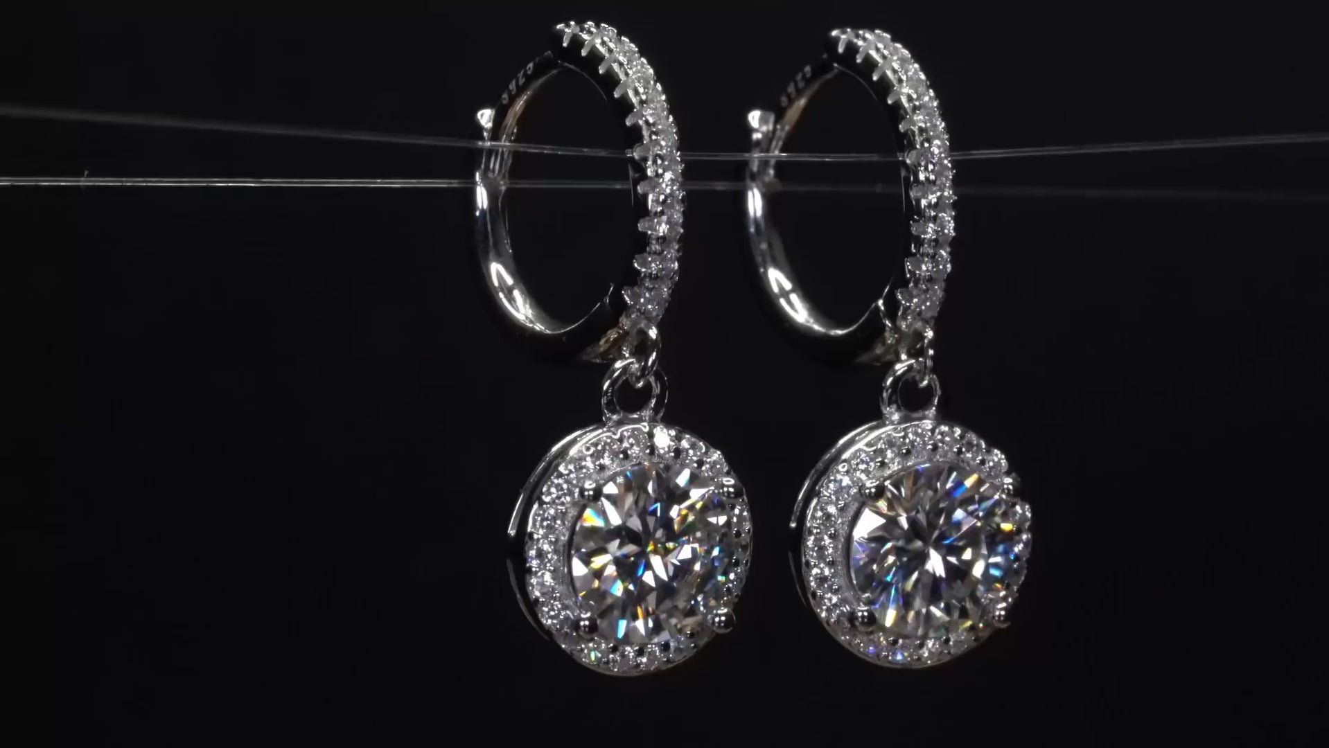 Moissanite Schmuck Halo Ohrringe hängend an Creolen im video drehend   