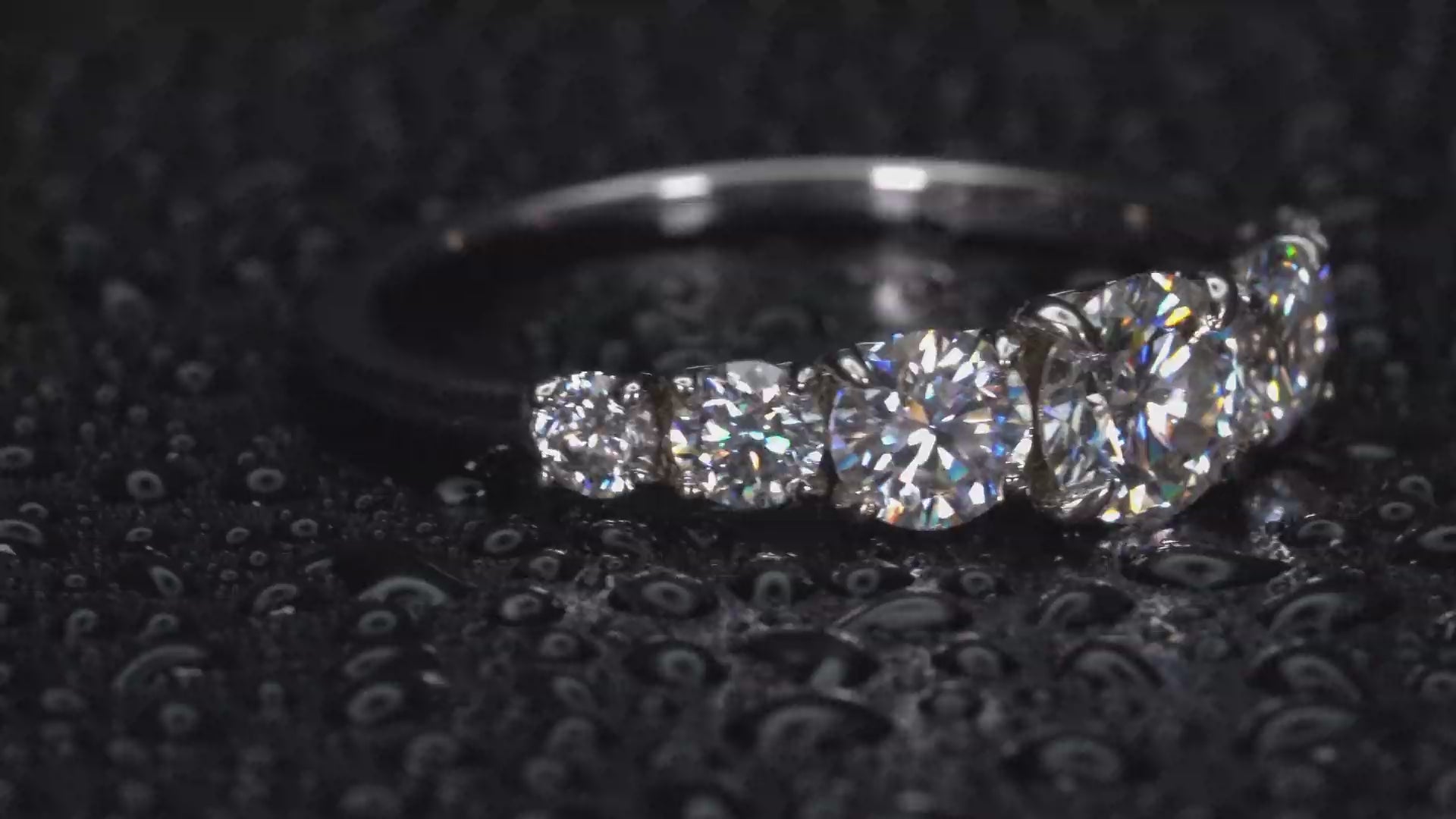 Drehender Moissanite Ring mit 5 Steinen im Größenverlauf, extremes Funkeln und Lichtreflexion im echten Licht sichtbar, keine KI, echte Aufnahme