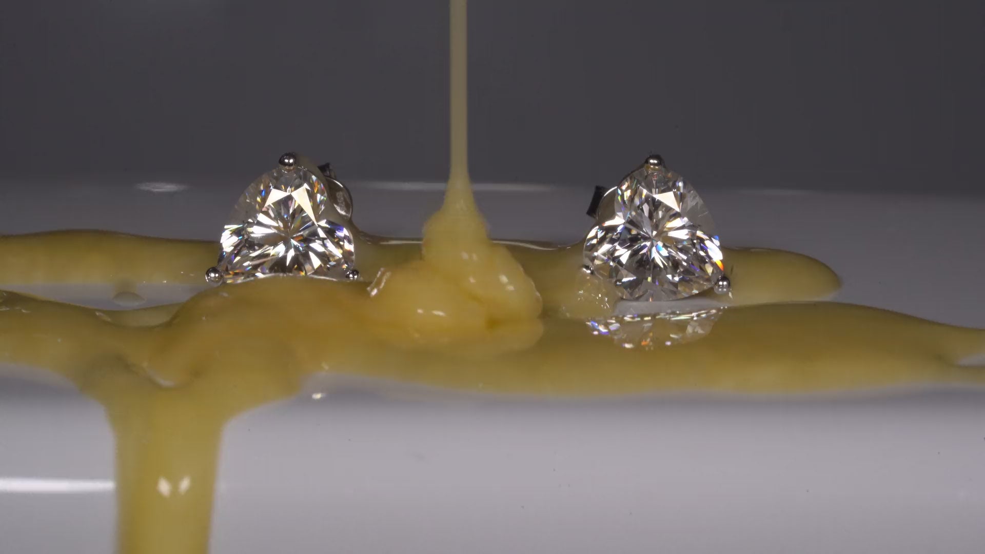 Video in dem Moissanite Herz Ohrringe von Shampoo übergossen werden und trotzdem funkeln