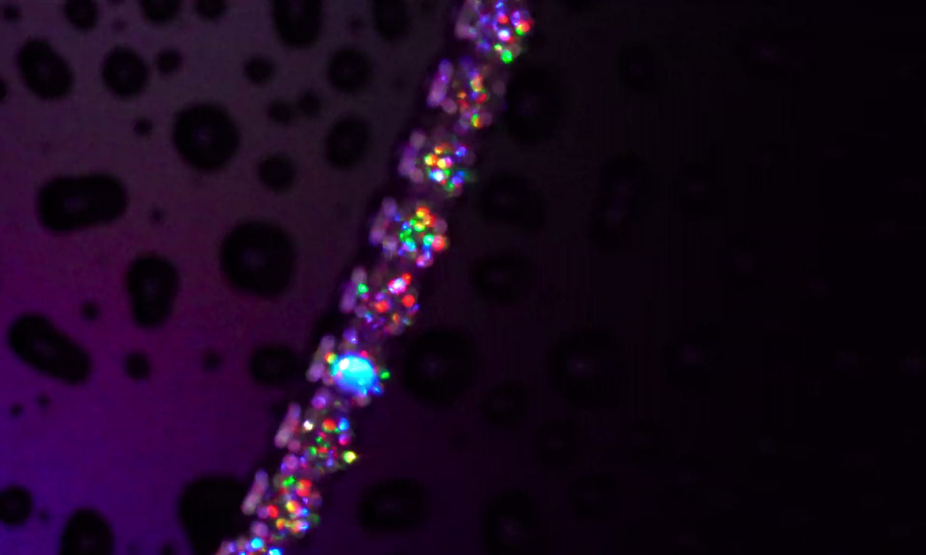 2 mm Moissanite Tennis-Kette im Brillantschliff mit sichtbar  starkem Funkeln als Diamant in bunten RGB-Discolicht und Partylicht.