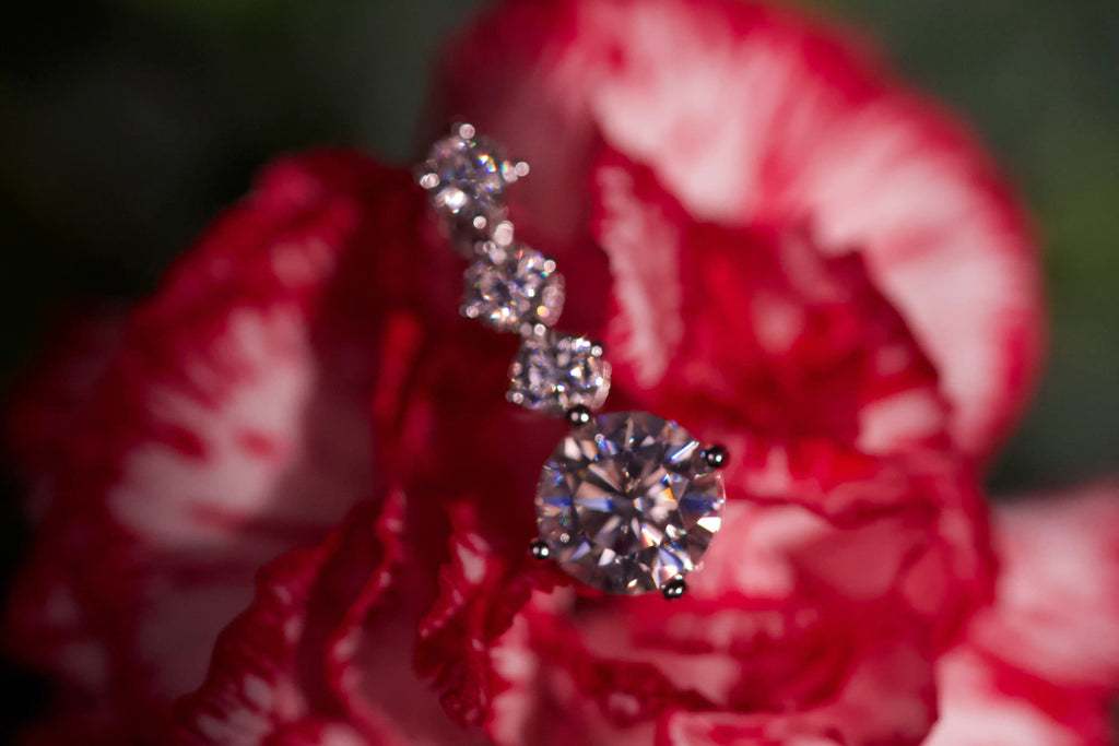 Unscharfe Makroaufnahme von funkelnden Moissanite Hängeohrringen im echten Licht. Zeitloser 925 Silber Schmuck mit diamantähnlicher Härte für langlebigen Alltagsschmuck und elegante Geschenke mit intensivem Funkeln.

